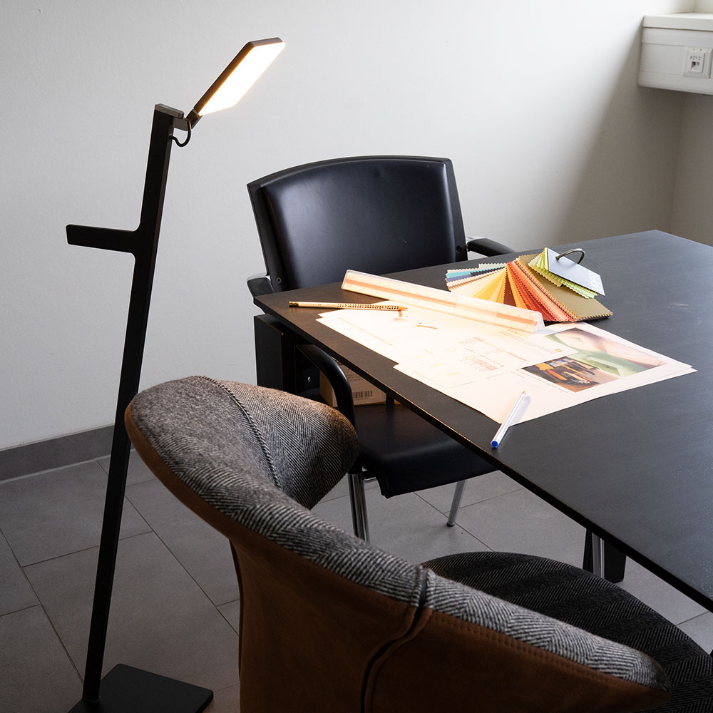 Nimbus Roxxane Leggera 101 CL LED-Leseleuchte mit schlankem, modernem Design und ber&uuml;hrungsloser Gestensteuerung am Leuchtenkopf. Die Abbildung zeigt das stufenlose Dimmen sowie das Ein- und Ausschalten durch Wisch- und Haltegesten.